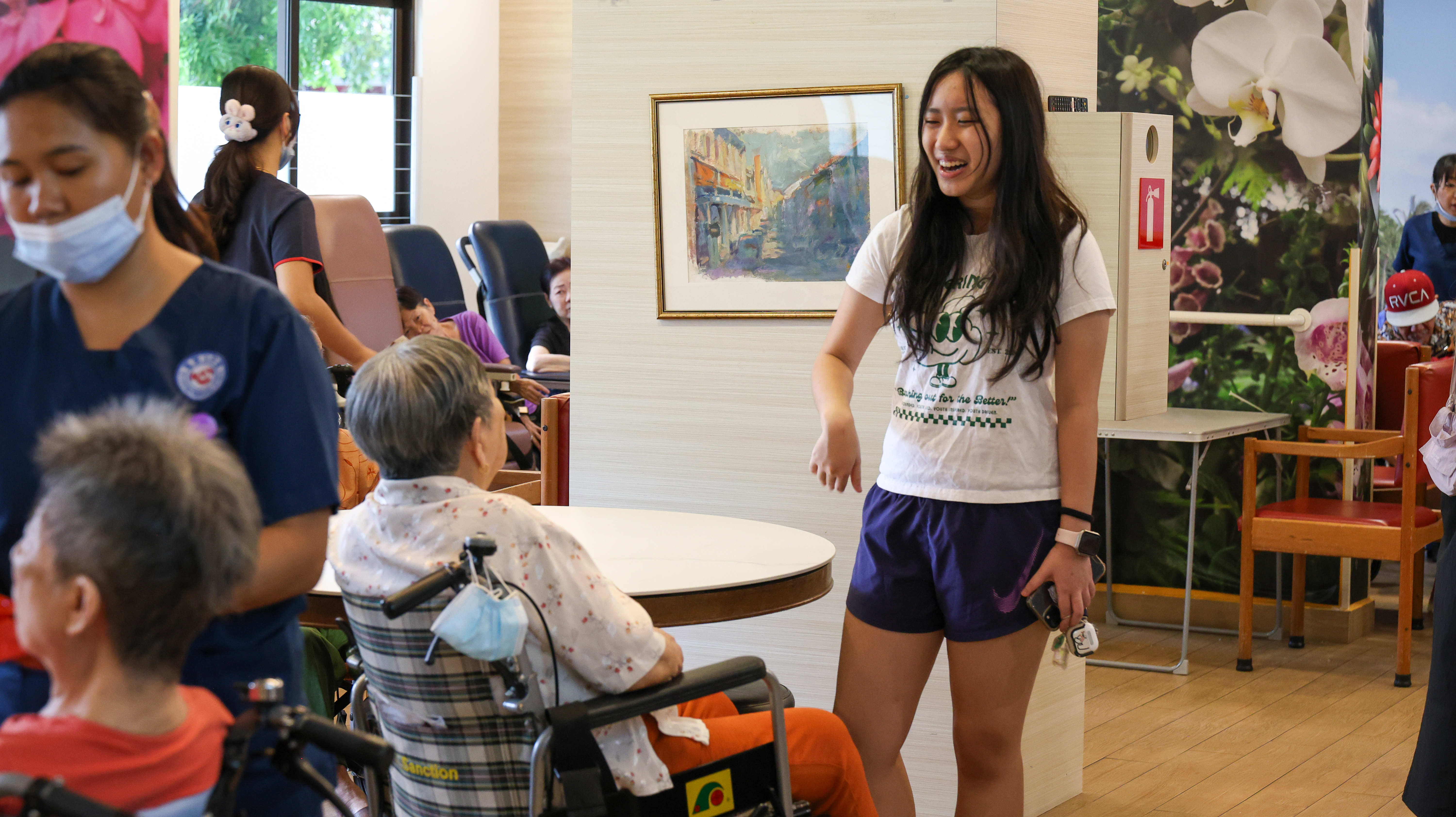 Raean Cheong interacting with a senior in a wheelchair